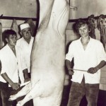 V súkromnom bitúnku na Šiestej ulici v Kovačici pri „takmer dvestokilogramovom bravovi“ sa roku 1970 ocitli: (zľava) mäsiar – pomocník Adam Strakúšek, majiteľ bitúnku a mäsiarne Ján Šiška a mäsiar – pomocník Štefan Kuchárik
